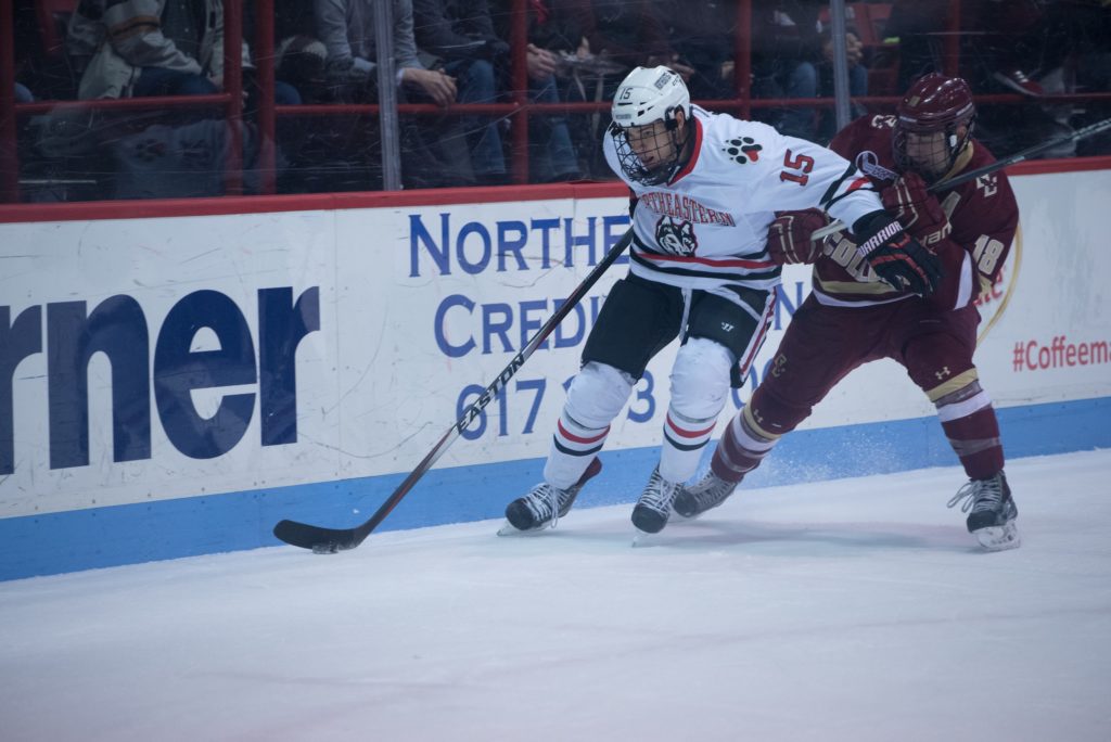 Junior forward Kevin Roy holds back Boston College Eagles senior forward Michael Sit in the hockey game at Matthews Arena on Friday, Jan. 9. The Huskies Tied against the Eagles in the game 1-1.