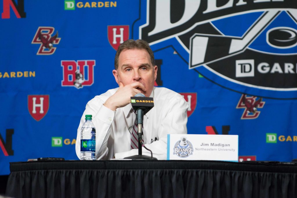 Head Coach Jim Madigan holds his hand to his face during the press conference after Northeasters loss to Boston University.