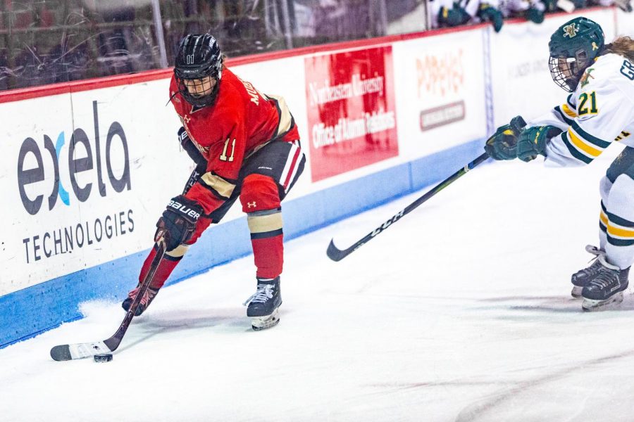 Sophomore forward Alina Mueller controls the puck along the boards in a game against Vermont last season.