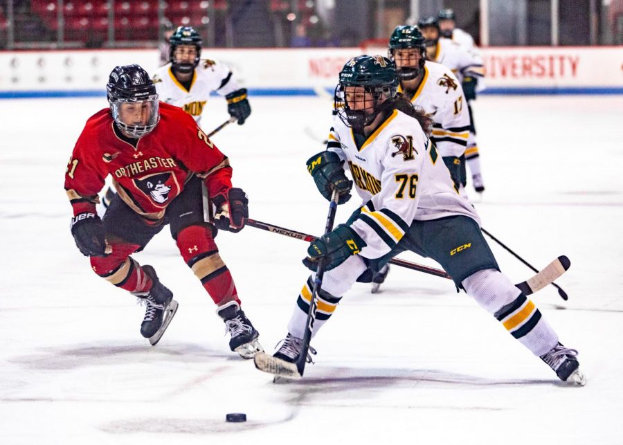 Junior defender Paige Capistran pressures Vermont defender Maude Poulin-Labelle as she controls the puck in a prior game. The two teams will face off this weekend in the Hockey East playoffs.