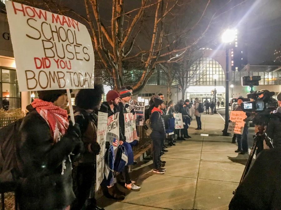 A group of community members protest Raytheon outside of NU's employee panel.