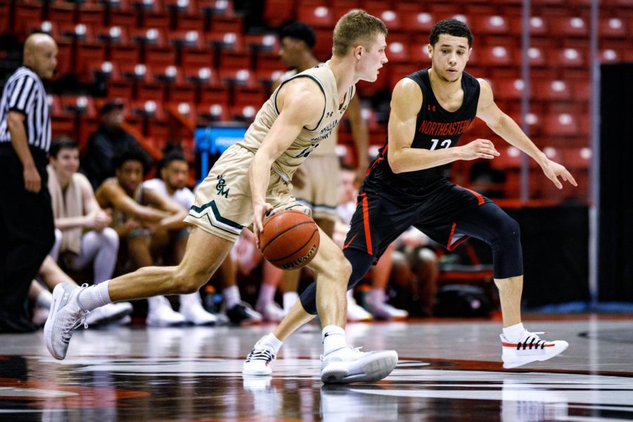 Junior guard Jordan Roland defends against a William and Mary player in a prior game. Roland is in his first year at NU after transferring from George Washington.