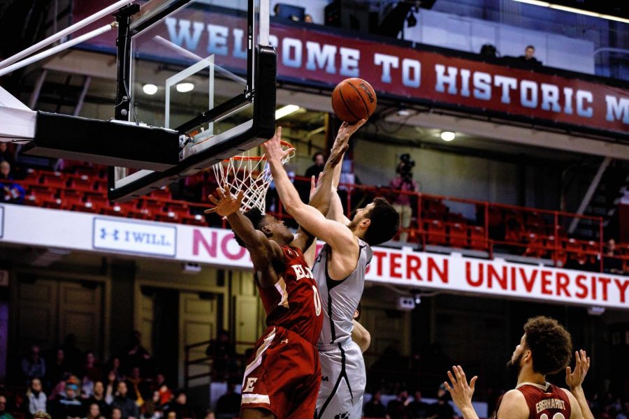 Senior guard Vasa Pusica puts up a shot in traffic in a prior game against Elon. Pusica led the Huskies with 19 points Thursday.