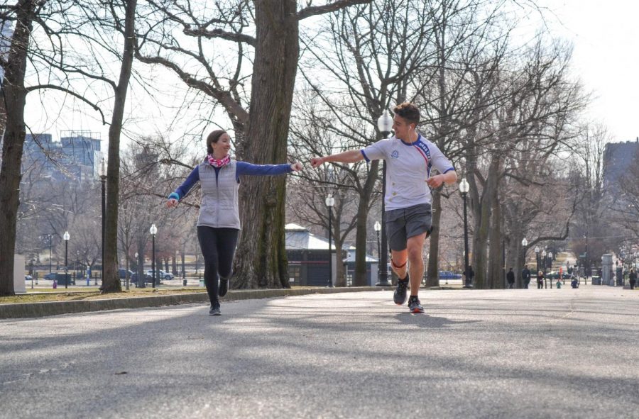 Peter Cunningham (right) and his teammate Jackie Creasey reach out for a fist bump during a March 20 training run in preparation for the Boston Marathon.