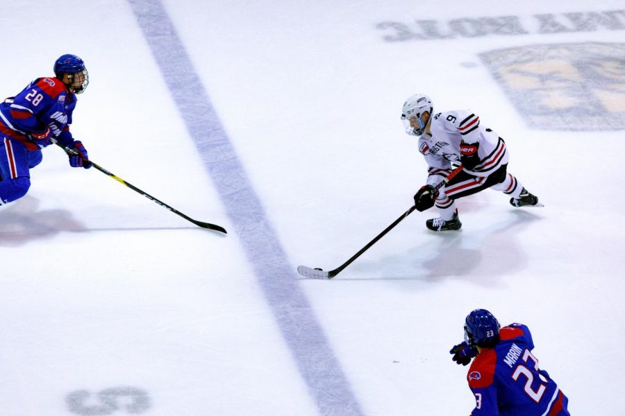 Sophomore forward Tyler Madden evades defenders in a game last season against UMass Lowell.