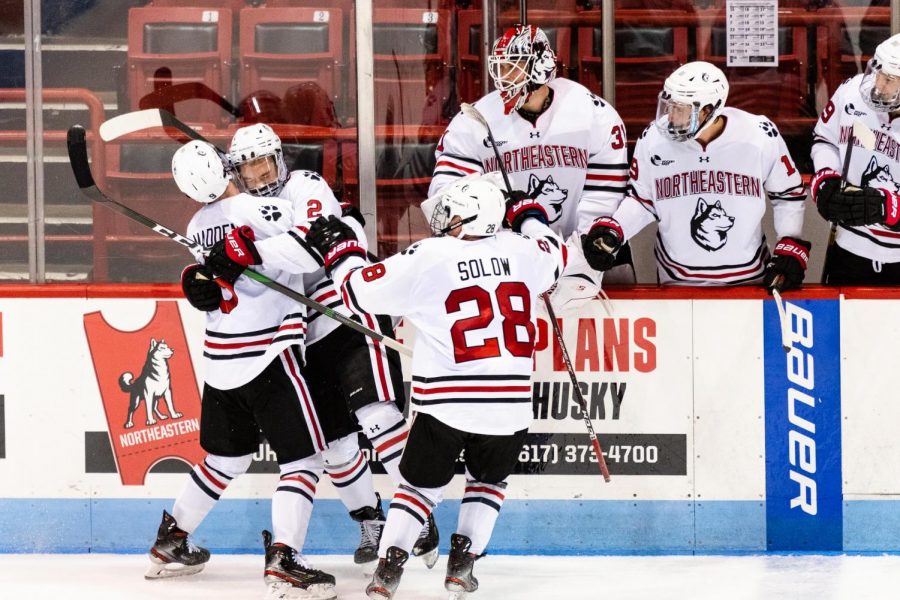 Sophomore defenseman Jordan Harris (center) celebrates with teammates Tyler Madden (left) and Zach Solow after scoring against UMass Tuesday night.