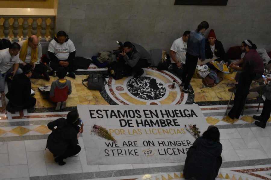 Hunger+strikers+line+the+floor+of+the+State+House+with+signs+protesting+the+15-year+wait+to+legalize+drivers+licenses+for+undocumented+immigrants.+