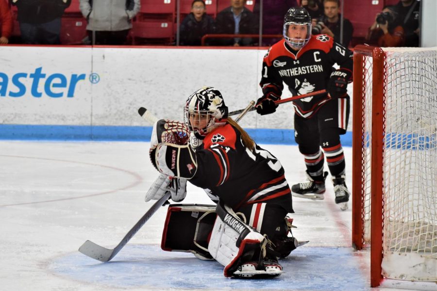 Frankel makes a save during the Womens Beanpot as her captain, Paige Capistran, looks on.