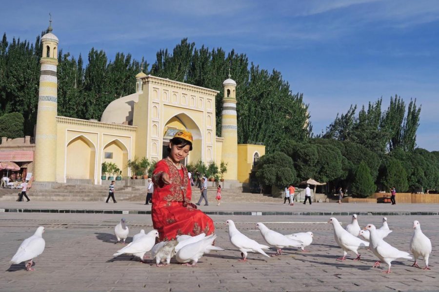 A child feeds doves in Kashgar, a historic city in the Uyghur Autonomous Region.