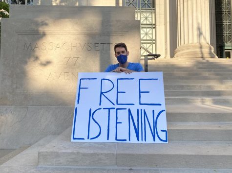 Kip Clark sitting with his 'free listening' sign.