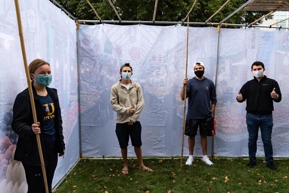 Students stand in the Sukkah built by the Alpha Epsilon Pi fraternity