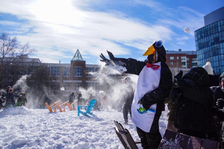 A student dressed in a penguin costume blocks a midair snowball. Northeastern canceled classes scheduled for Feb. 13 in anticipation of a snow storm.
