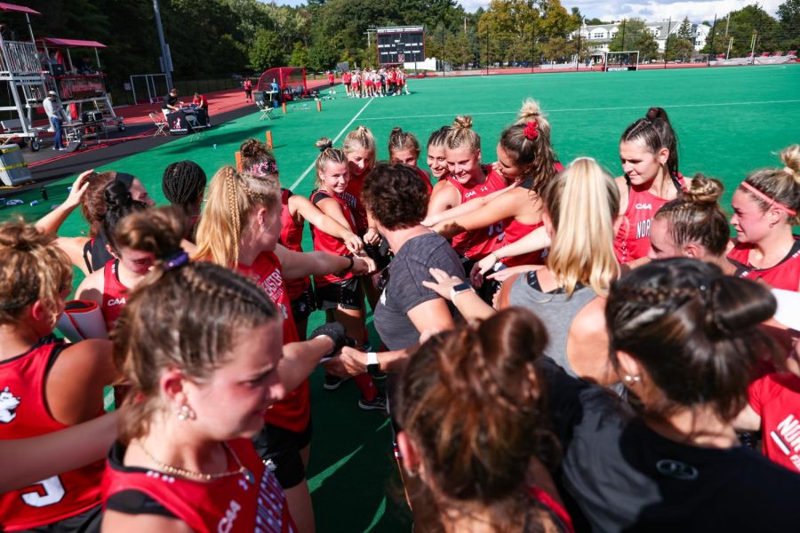 The+womens+field+hockey+team+huddles+together+on+the+field.+