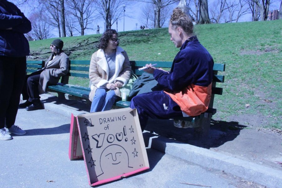 Nick Shea draws a portrait of customer Iliana Vidal in the Boston Common. Photo credits to Cathy Ching.