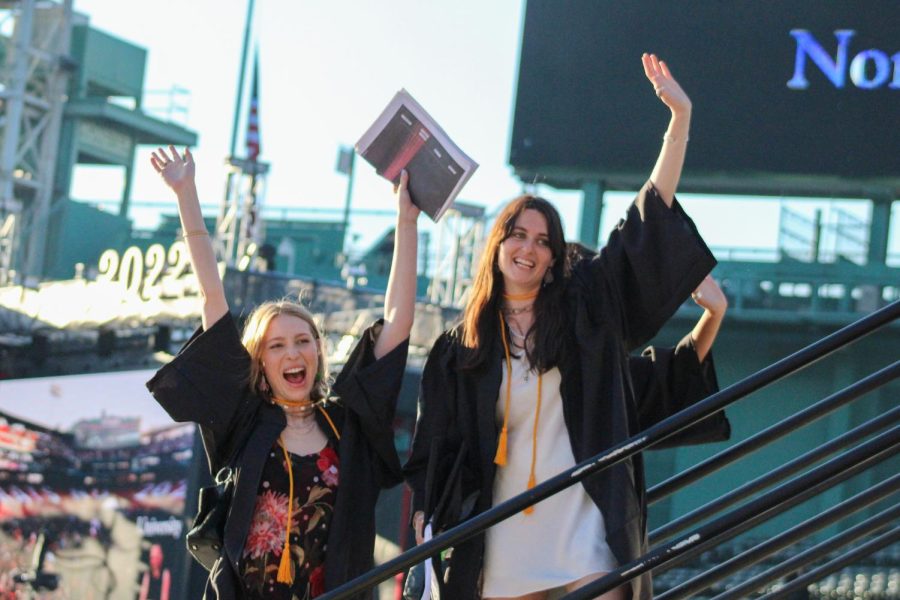 Newly graduated students wave at supporters after a hot and sunny ceremony. The graduates sat on the field and family and friends were in the stands. 