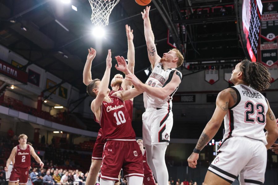 Redshirt+senior+Chris+Doherty+goes+for+a+layup+while+two+Cougars+try+to+block+him.+Doherty+tallied+11+points+in+Saturday%E2%80%99s+game%2C+the+most+of+any+player+on+Northeastern%E2%80%99s+team.+