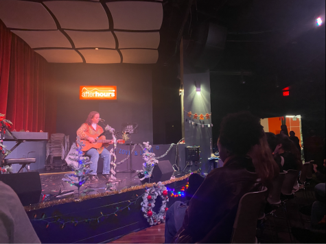 Second-year health science major Kelly Walsh performs at NU Pride and Live Music Associations open mic night. She performed a self-composed medley and an original song called “Home,” which described the paradox of feeling like an outsider amid coming home for the holidays.
