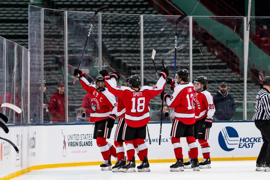 Spott celebrates with his teammates after senior forward Aidan McDonough scores the Huskies’ first goal against UConn at Frozen Fenway. Spott has two assists on the season.