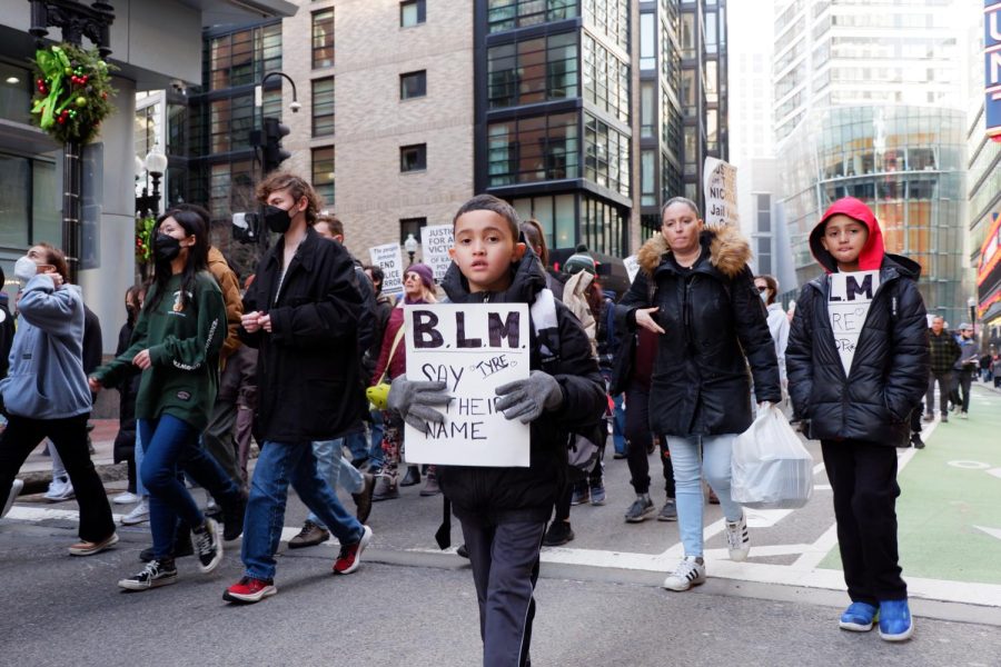 A young boy marches through the streets of downtown Boston holding a sign saying “B.L.M. Say their name. Tyre,” during Saturday’s protest. While the crowd was initially about 150 people, it increased to around 500 as many joined en route.