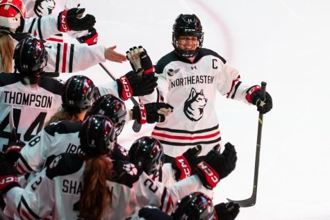 Graduate student forward Alina Müller high-fives her teammates after a goal in the Hockey East quarterfinal. During the game, Müller broke the tournament record for career points and tied the Northeastern program record for career points. 