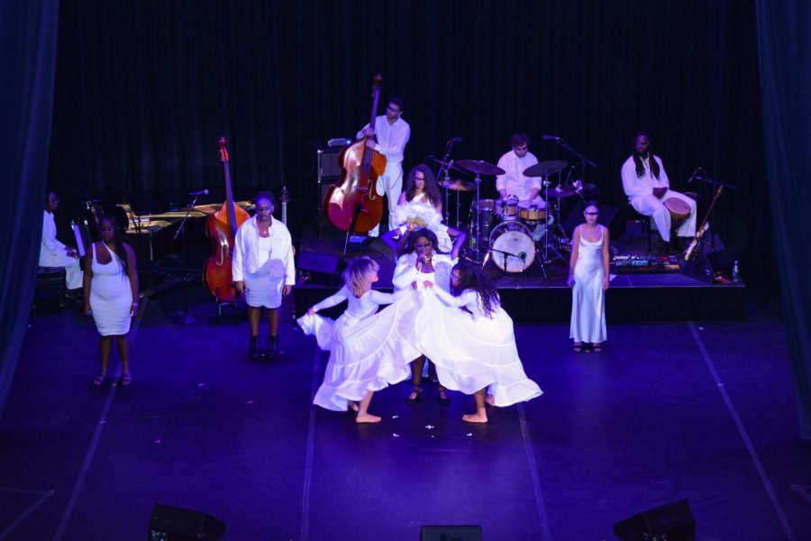 Mae-Ya Carter Ryan sings center stage while dancers in long white skirts surround her. The dancers depicted a vessel from which Ryan, the “Visionary of Spirit,” emerged.