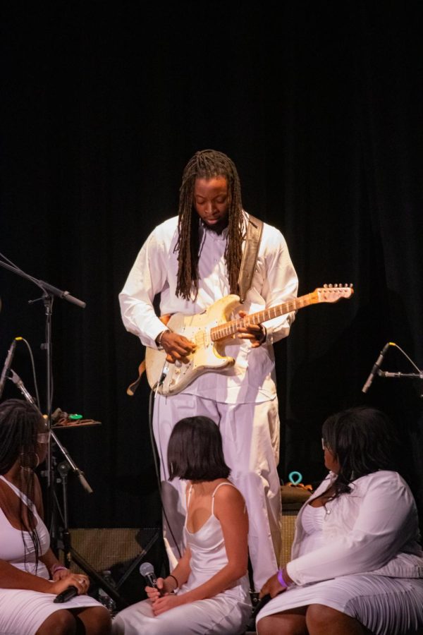 Steven Amoikon plays an electric guitar on stage surrounded by members of the Collective. This piece depicted the spirit of perception and is a part of Orji’s upcoming second album.