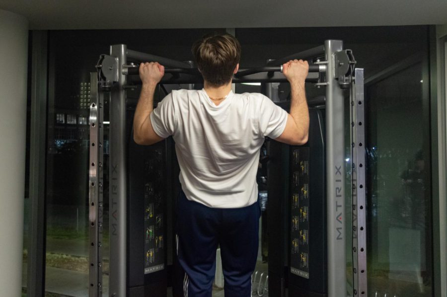 Nick Gallina works out at the International Village gym. He did pull-ups on a Matrix machine.