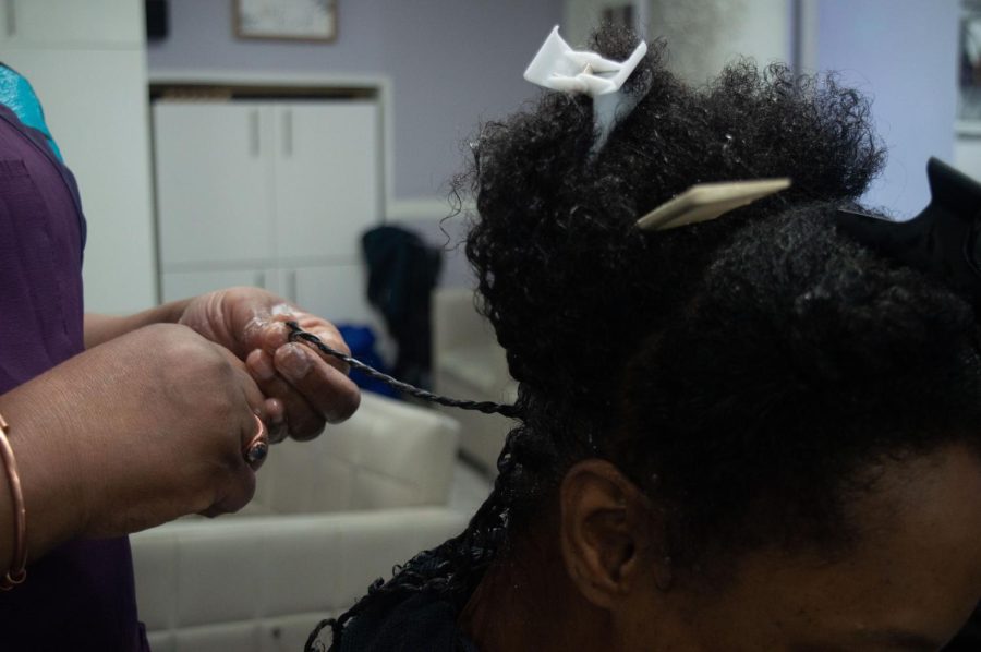 A hairstylist twists a clients hair at Lizs Hair Care. Black women have often been compelled to meet Eurocentric beauty standards and struggled to get beauty products that worked with their hair.