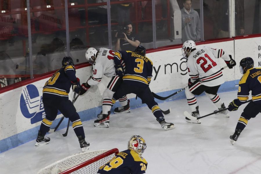 Novak is caught in a tussle at the boards by the Merrimack Warriors. The Huskies won the January 21 game 1-0, taking down the top team in Hockey East for the second consecutive night.