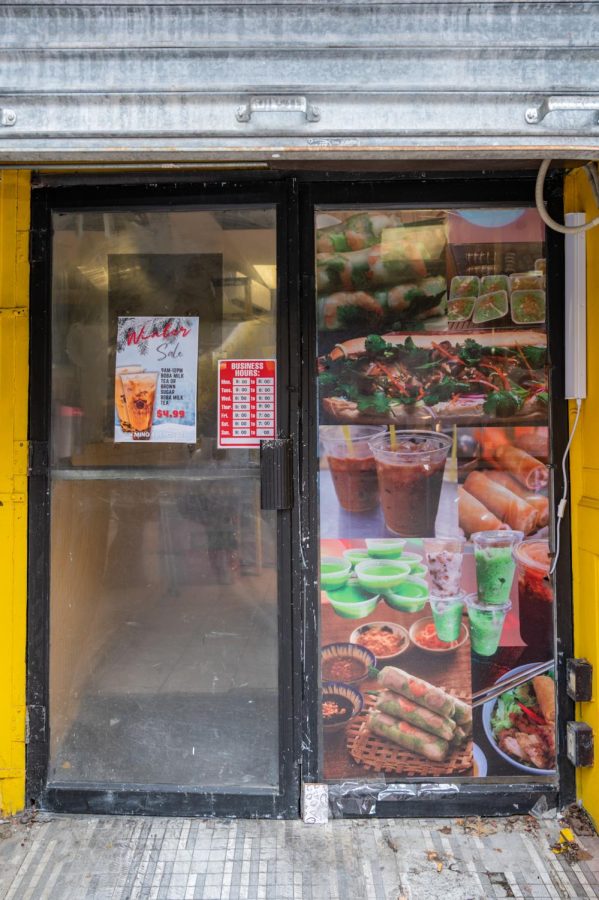Photos of offered dishes decorate the entrance to Banh Mi Huong Que. Customers have frequented the cash-only restaurant for affordable, quick and traditional food.