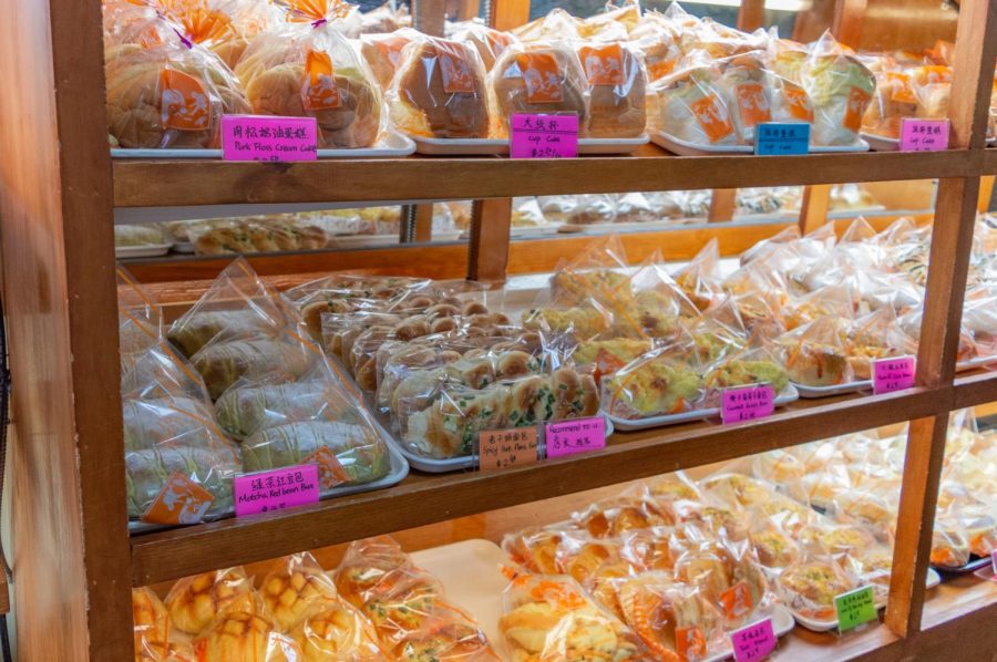 Cakes and buns of various flavors and shapes sit on display in Taiwan Bakery. Many bread-based treats in the bakery are packaged in plastic bags and neatly organized for an easy shopping experience.