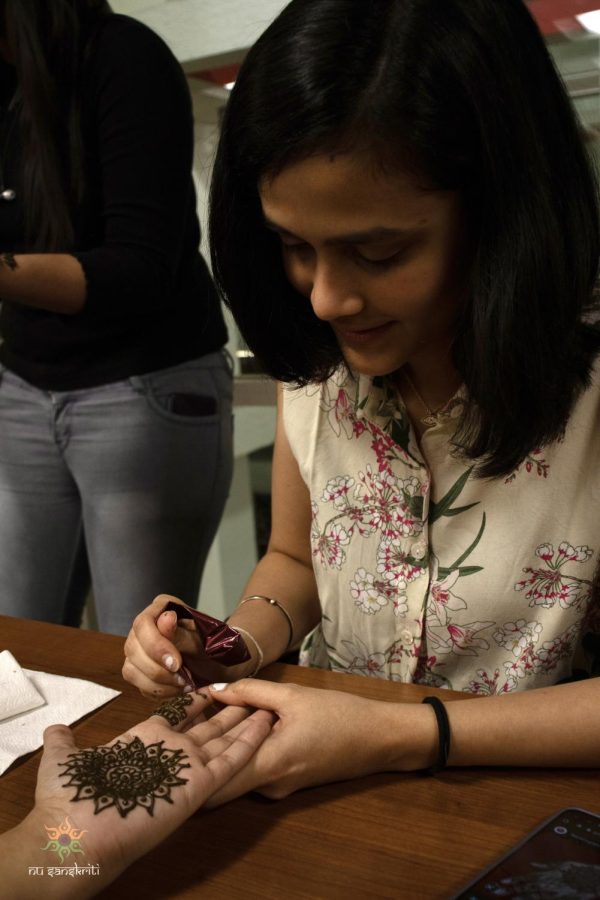 A member of NU Sanskriti paints Mehndi, or henna, on another members hand during an event held as part of the clubs Indian History Month celebration. While planning the month-long celebration, club leaders aimed to provide a platform for students to express their identity. Photo courtesy of NU Sanskriti.