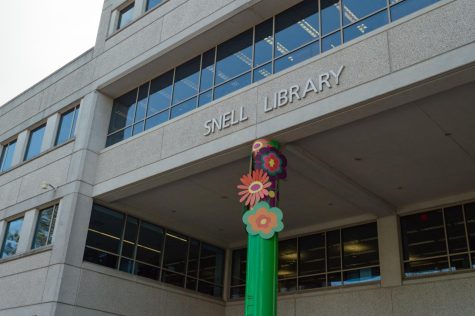 A decorated pole with floral decorations marks the main entrance to Snell Library. Many students have found it difficult to find a quiet and comfortable space to work in the commonly-overcrowded building.