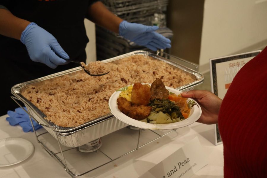 A volunteer spoons Caribbean brown rice onto a student’s plate at Taste of the Diaspora. Brown rice has served as a staple dish in many Caribbean cuisines for hundreds of years.