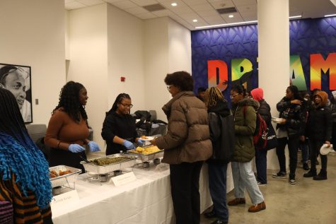 Students line up to taste the curry goat offered at Taste of the Diaspora. Curry goat was one of the Caribbean dishes featured at the event and is served with plantains and brown rice.