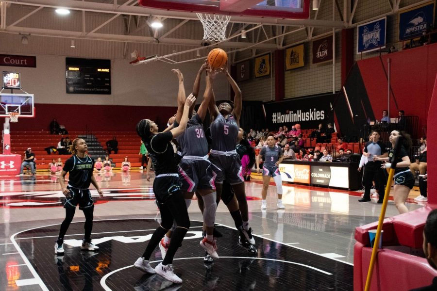 Junior guard Halle Idowu (right) and junior forward Deja Bristol (left) lunge to catch a rebound for the Huskies. Northeastern will play Stony Brook in the CAA Quarterfinals Friday at 7:30 p.m.