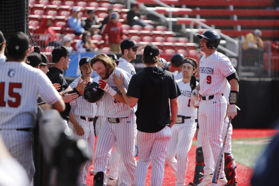 The team congratulates graduate student first baseman Tyler MacGregor after his home run took him around the bases. MacGregors two home runs Tuesday were responsible for all three of the Huskies points that afternoon.