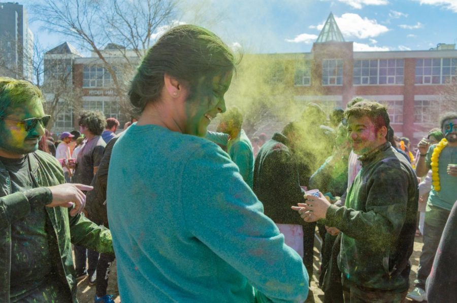An attendee smiles as her face becomes covered in green powder.
