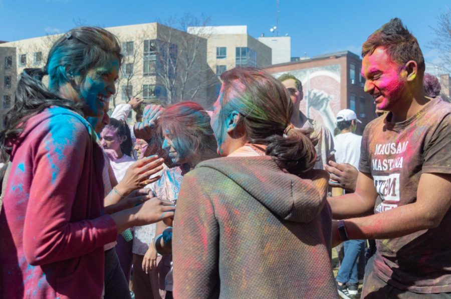 Attendees smile and laugh with each during the Holi celebration.