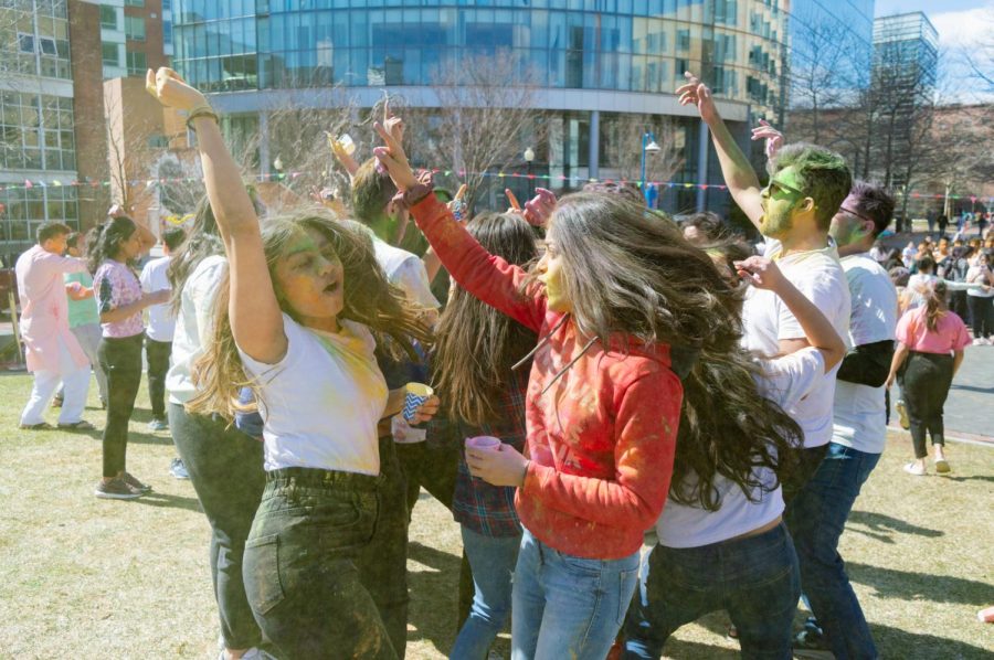 Students dance during a Holi celebration on Centennial Common March 19. Also known as the Festival of Colors, cups of colored pigment were handed out to throw in the air and smear on other attendees faces.