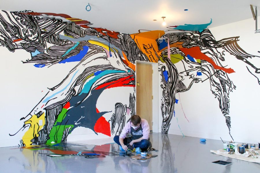 Northeastern alumnus Alexander Langrock paints the interior of a house in Chestnut Hill. Commissioned by the house’s owners, associate teaching professor Sophia Ainslie helped guide Langrock and a team of students in creating a mural based on X-rays of her mother’s abdomen.