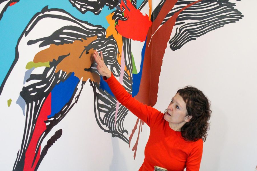 Ainslie gestures towards a section of the mural.