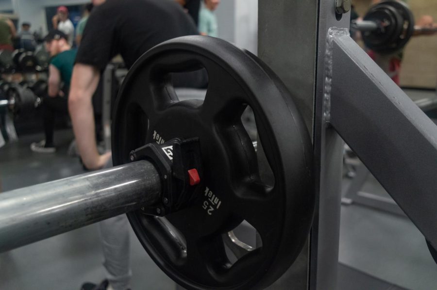 A 25-pound weight plate rests on a bench press in Marino Recreational Center. Following an alterncation between a fitness consultant and management that gained attention on Reddit, multiple Marino employees are calling for change. 