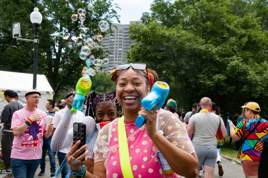 Two women smile while holding bubble guns at the Pride Festival. The festival included local LGBTQ+ pop up shops and organizations, food and musical performances.