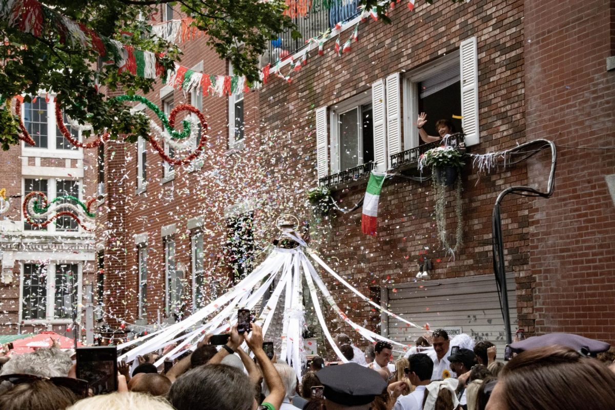 Confetti fills the air above the statue of St. Anthony while a woman waves from a window above