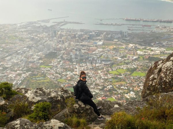 Crystal Zhang, third-year computer science and design combined major, sits in the rain on the edge of Table Mountain overlooking Cape Town City Centre and Woodstock. Students on the Social and Sustainable Entrepreneurship Dialogue were able to explore Cape Town by hiking up Table Mountain and Lion’s Head Peak. Photo courtesy Ethan Truong.