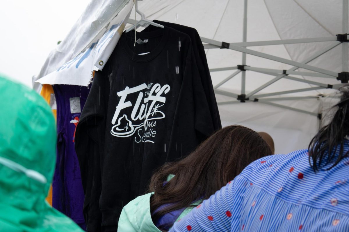 People browse items at the festival merchandise booth, where items such as magnets, shirts and comic books could be purchased. Although light rain made game and booth environments difficult, a majority of the vendors utilized tents to continue sales.