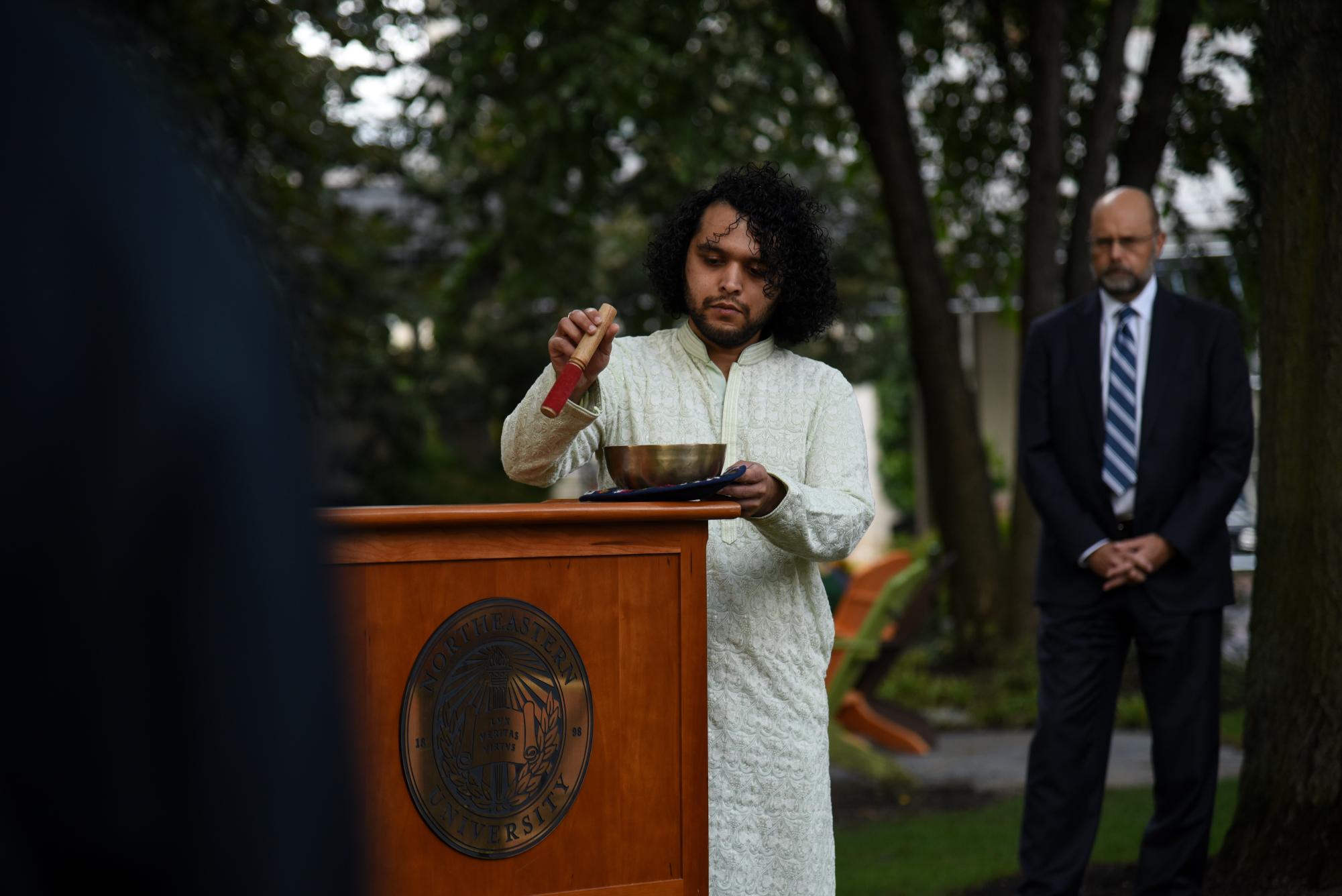 Sagar Rajpal plays chimes from a singing bowl. The chimes were played to give a moment of peace and remembrance in honor of Jaahnavi Kandula.