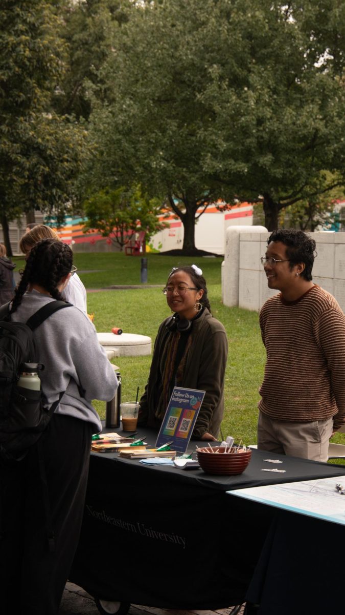 A Northeastern student engages with hosts at the Center for Cultural Engagement table. The Center for Cultural Engagement educated students on their organization and the different projects they have, such as their Empower Retreat.