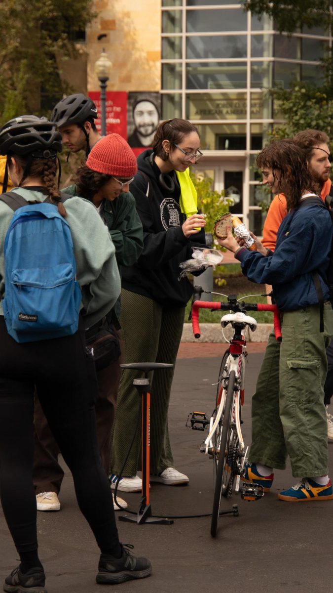 Northeastern students enjoy sandwiches together while waiting for their bikes to be checked by Bikes Not Bombs. Students mingled with and met new people at the fair.